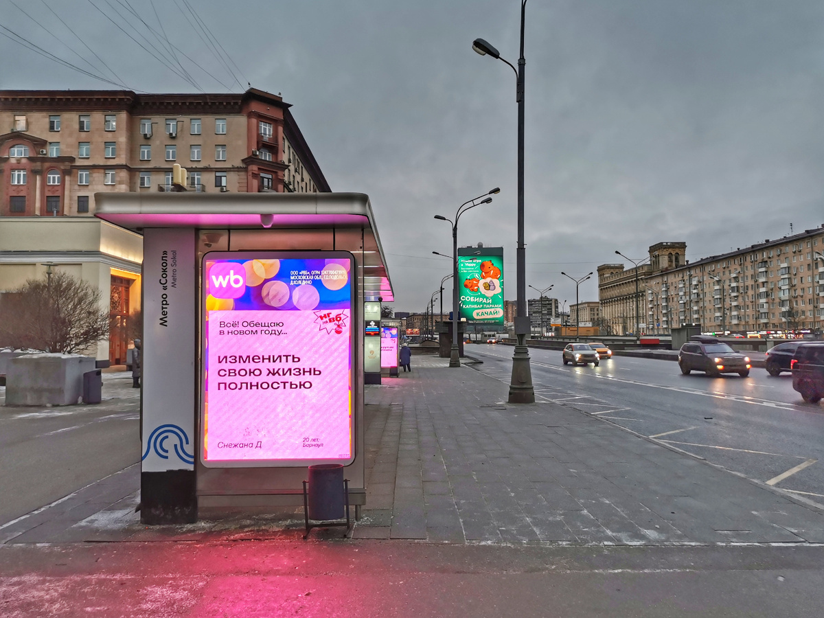 Розовая от рекламы остановка "Метро "Сокол"" на нечётной стороне Ленинградского проспекта. 