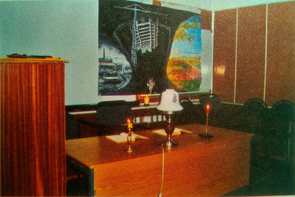 Рис. 1. Скромная обстановка актового зала Диспансера (НД №1 ЮАО), где долгие годы проходили репетиции и выступления Реалистического клинико-психотерапевтического театра-сообщества (РКПТС). Помимо уютного света настольной электрической лампы, горят живые свечи. На стене — декорация Р.Г. Кошкаровой к постановке «Психиатр Гречихин» (автор — М.Е. Бурно), 2003 [4, ил. 7]