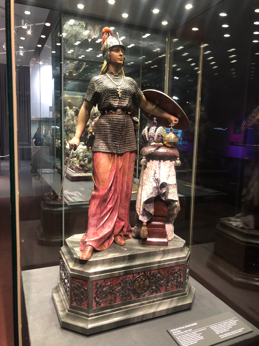 Скульптурная композиция "Россия" (2022-2023). Екатеринбург. Студия камнерезного искусства "Святогор", автор модели П. Лапыш, камнерез С. Ширяев, шлифовщик А. Атемасов, ювелиры Д. Евдокимов и Д. Бабушкин. Джеспилит, гематит, кремень, родонит, халцедон, яшмоид, пирит, топазы, фианиты, искусственный рубин, искусственный сапфир, яшма, агат моховой, латунь, серебро