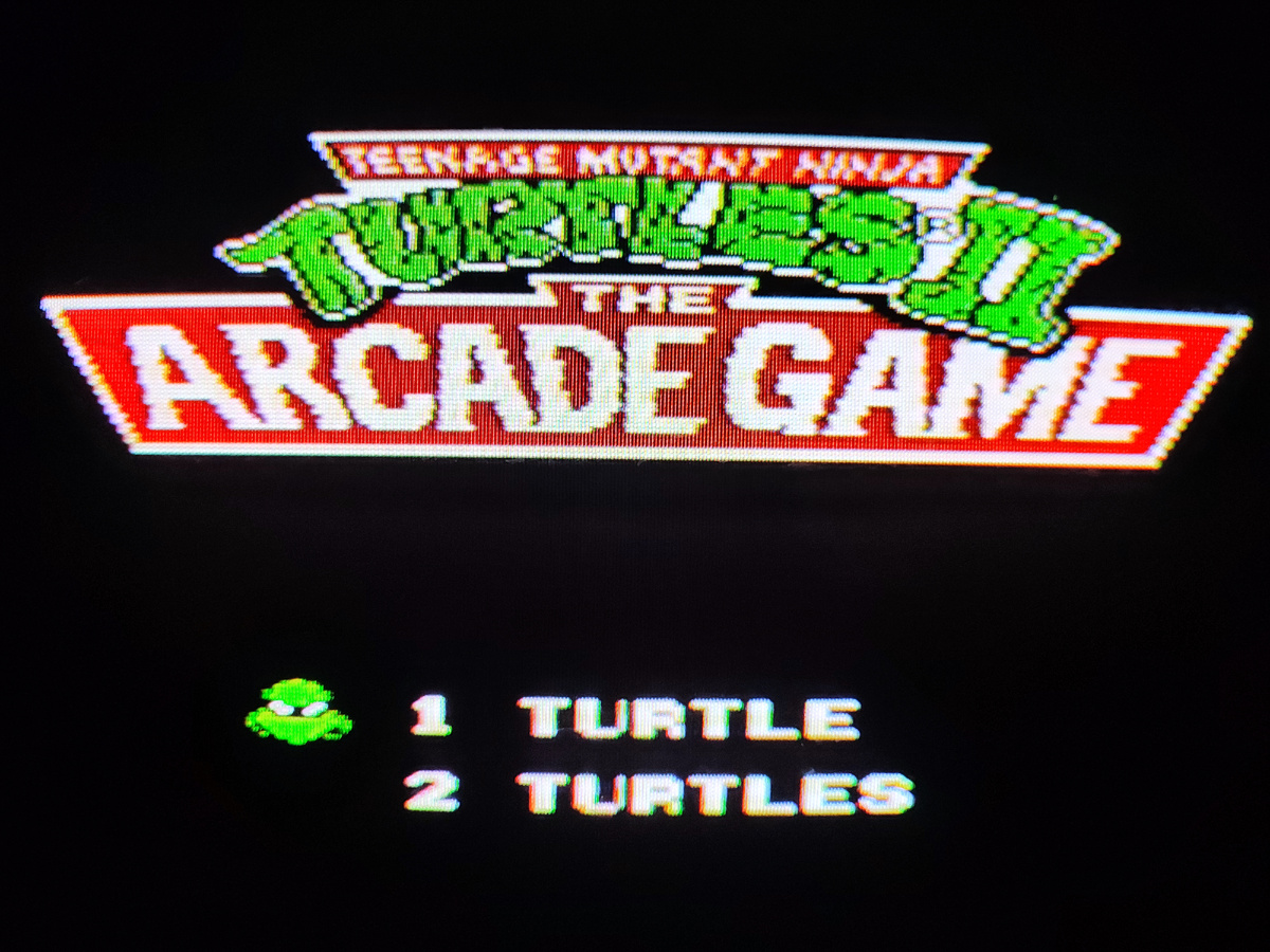 Фото сделаны мной. На фото игра "Ninja Turtles 2". Оригинал игры "Teenage Mutant Ninja Turtles 2: The Arcade Game" был разработан Konami и издан Konami, Image Works, Ultra Games, Ubisoft в 1989,.г. для аркадных автоматов, а затем и для других приставок NES, Amiga, Amstrad CPC, Atari ST, Commodore 64, DOS, ZX Spectrum, PlayStation 2, Xbox, GameCube, XBLA. Фото демонстрирует начальную заставку игры, а так же общий визуальный фон игры. Подробнее об этом рассказано в статье. Все материалы принадлежат правообладателям и размещены исключительно в информационных целях.