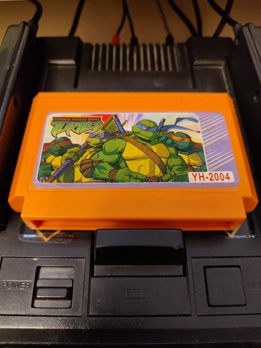 Фото сделаны мной. На фото игра "Ninja Turtles 2". Оригинал игры "Teenage Mutant Ninja Turtles 2: The Arcade Game" был разработан Konami и издан Konami, Image Works, Ultra Games, Ubisoft в 1989,.г. для аркадных автоматов, а затем и для других приставок NES, Amiga, Amstrad CPC, Atari ST, Commodore 64, DOS, ZX Spectrum, PlayStation 2, Xbox, GameCube, XBLA. Фото демонстрирует начальную заставку игры, а так же общий визуальный фон игры. Подробнее об этом рассказано в статье. Все материалы принадлежат правообладателям и размещены исключительно в информационных целях.