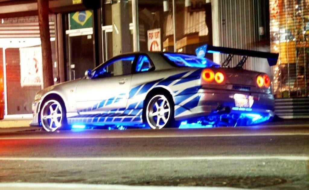    Nissan Skyline R34 GT-R На фоне популярности уличных гонок и тюнинга в начале нулевых подростки всего мира влюбились в серебристый «Скайлайн» с синими полосами из второго «Форсажа». На нем герой Пола Уокера выиграл гонку после зрелищного прыжка с моста (в реальности автомобиль вряд ли пережил бы такой трюк). R34 был оснащен двигателем с двойным турбонаддувом, который увеличивал мощность до 330 л.с.