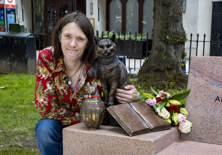 Джеймс Боуэн у памятника Бобу. Фотография с сайта https://londonist.com/london/features/street-cat-bob-statue-islington-green-angel