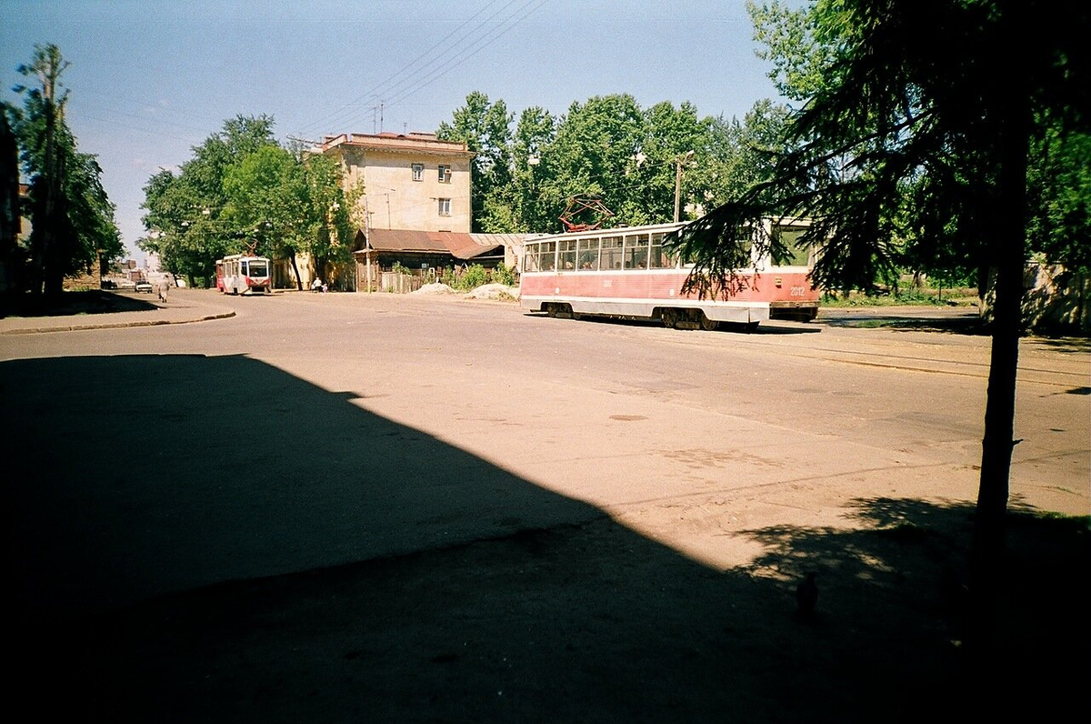Перекресток с Шаляпина. Где-то за трамваем (в тот момент тут, возможно, ходил не только 4 и 6, но и загадочный 22 из-за закрытия разворота 12 и 5 трамвая на Булаке). За спиной магазин мебели.