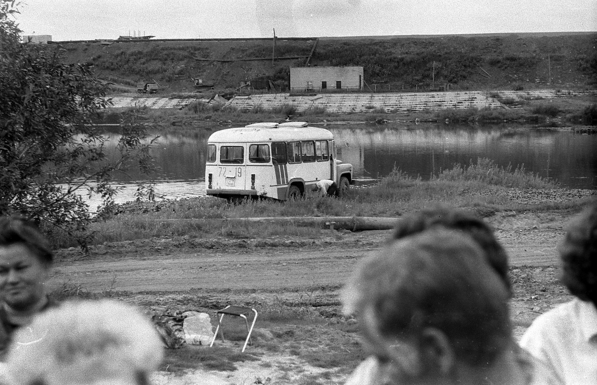 Водитель автобуса склонился к заднему колесу, дабы проверить, всё ли в порядке с техникой.