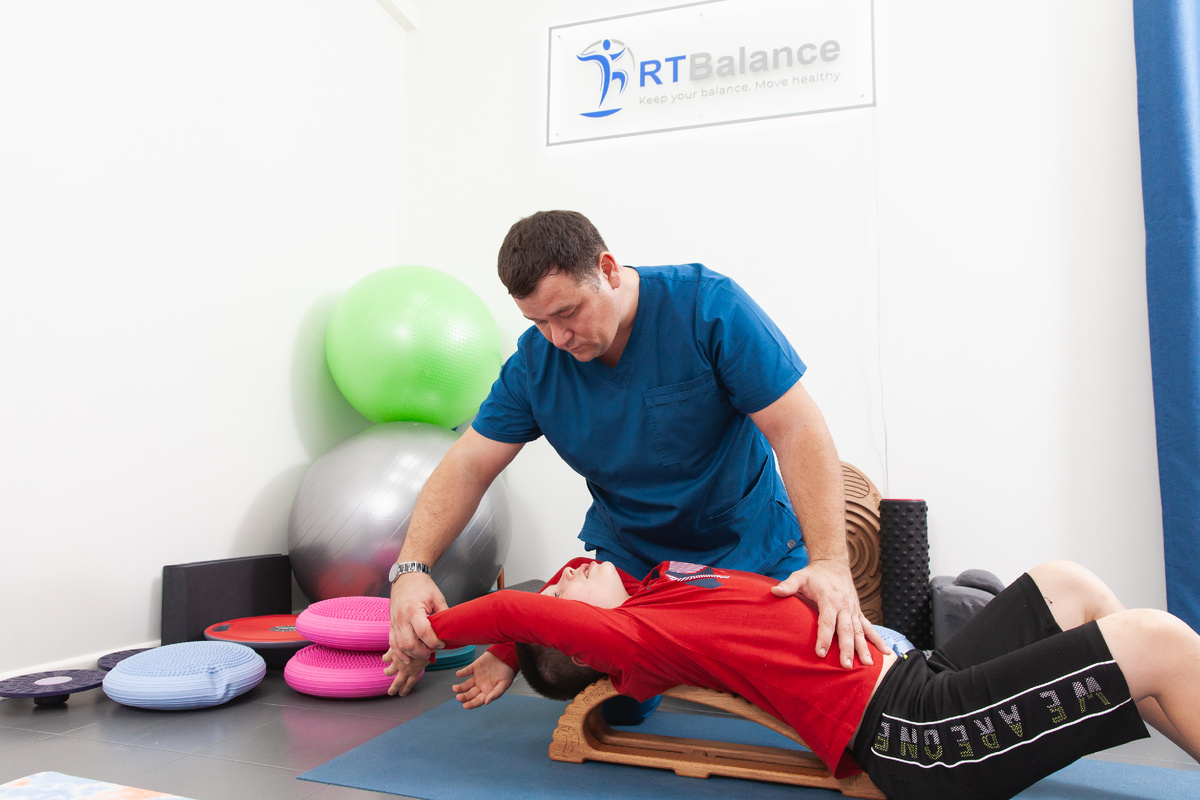 доктор Реут Вячеслав Вячеславович работает с пациентом на экстензоре RTBalance