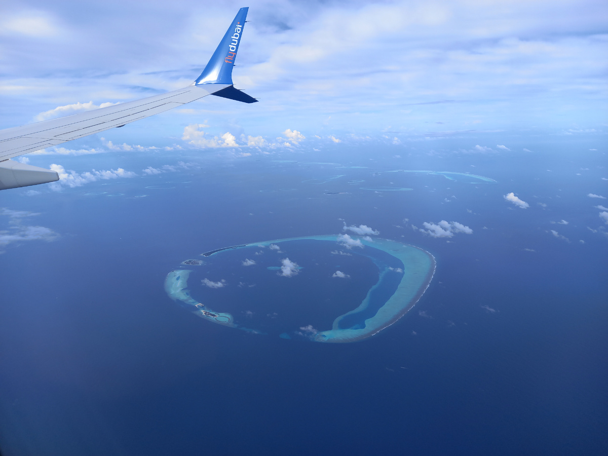 Под крылом самолета мальдивские острова.