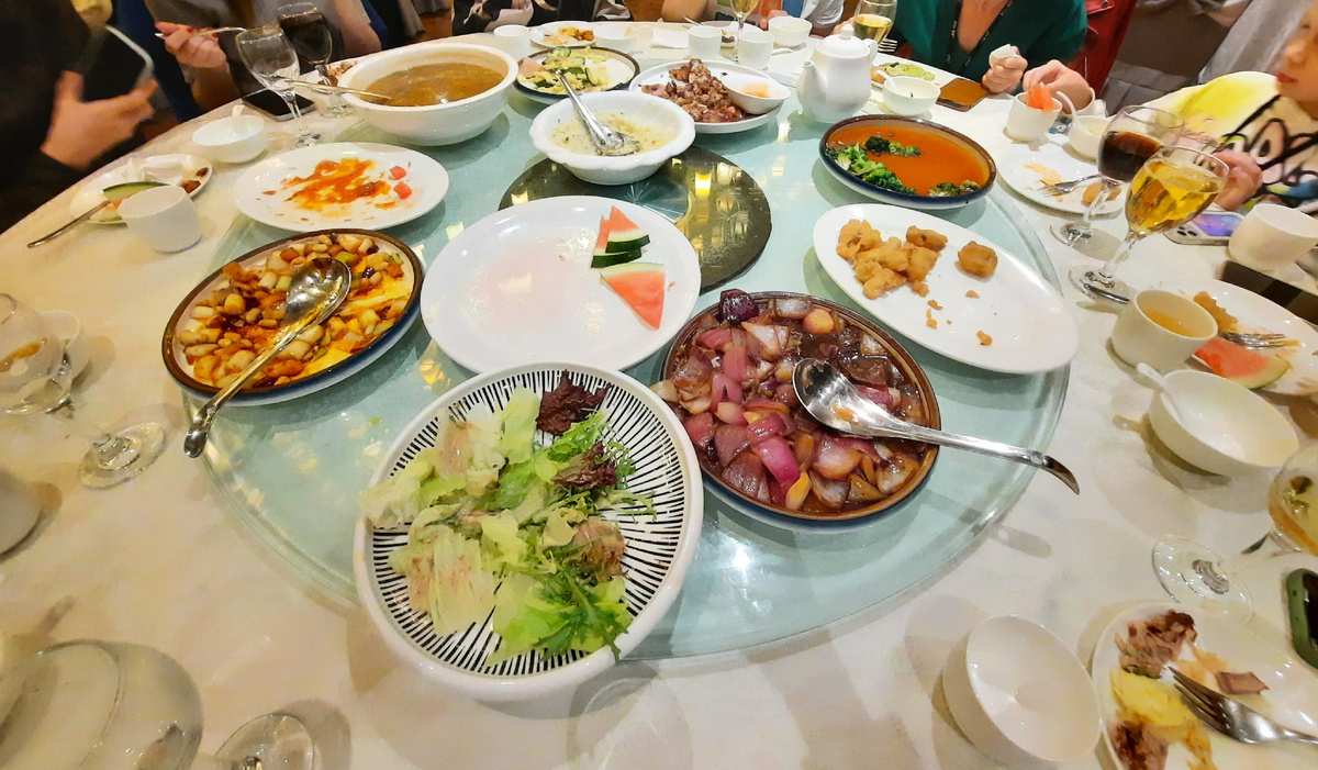 Еда обычно подается на круглый крутящийся столик посередине большого стола. Как правило есть большая супница с несоленым мясным бульоном и рис. Остальные блюда могут варьироваться. Каждый накладывает себе то, что он хочет.