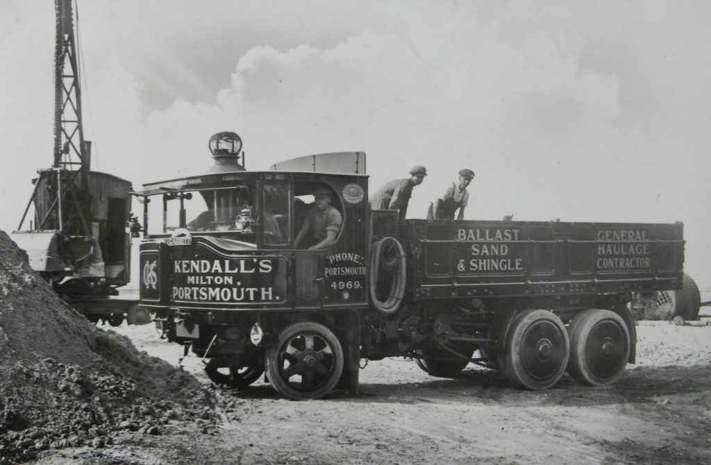 Трехосный паровой самосвал Garrett с цепной трансмиссией на дорожном строительстве.