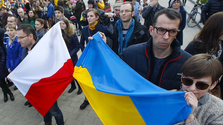    In this photo taken on Sunday, Feb. 23, 2014, people holding a Poland flag, left, and a Ukraine flag listen to speakers during a demonstration in Warsaw, Poland showing their support for protesters in Ukraine. Broken promises of help from the West. A tragic history of Russian invasion that goes back centuries. A painful awareness that conflicts in this volatile region are contagious. These are the factors that make nations across Eastern Europe watch events in Ukraine. Some countries like Poland, which shares a border with both Ukraine and Russia, are already starting to take precautionary measures. Polish Prime Minister Donald Tusk has warned that instability in Ukraine may be prolonged and lead Warsaw to upgrade its weapons. (AP Photo/Czarek Sokolowski) editor