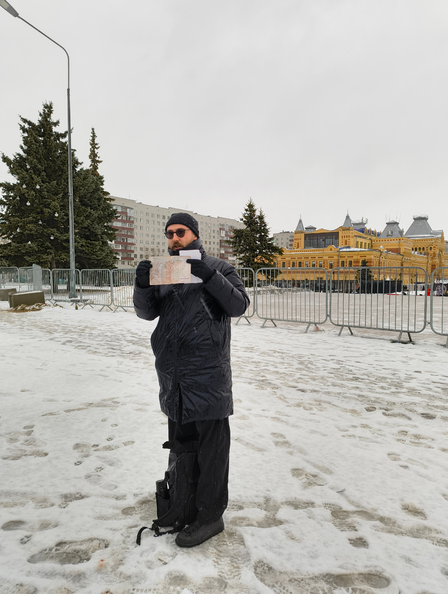 Начало экскурсии. Несравненный Дима Четыре. Под проливным новогодним дождем. На фоне главного ярмарочного дома. В новогодние праздники территория современной ярмарки ограждена металлическим забором с пропускной системой.