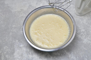 Шаг 2:
В глубокую миску вбейте яйца. Обязательно мойте яйца перед использованием, так как даже на кажущейся чистой скорлупе могут находиться вредные бактерии. Лучше всего использовать моющие средства для пищевых продуктов и щетку. Всыпьте ванилин и соль, которая сбалансирует и усилит вкус. Начните взбивать яйца на небольших скоростях миксера. Порциями всыпьте сахар, хорошо взбивая массу после каждого добавления. Взбивайте яйца с сахаром до пышной светлой массы.