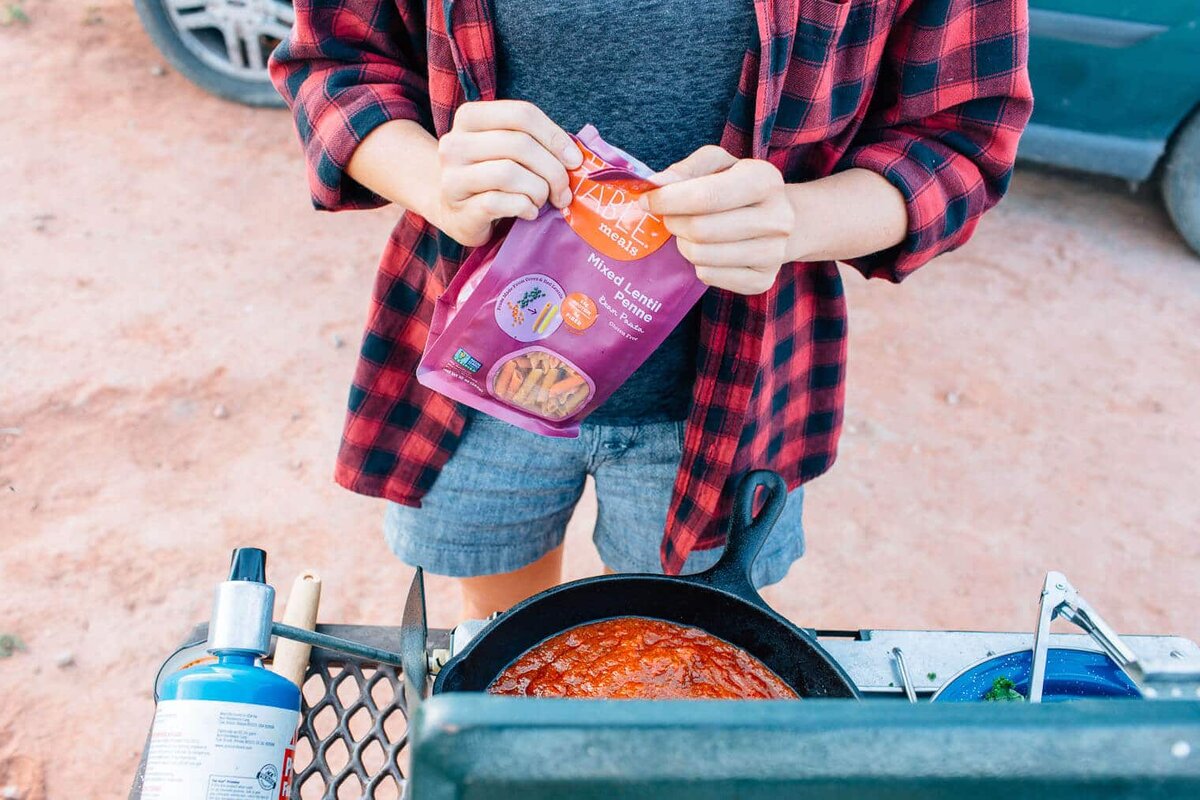 
Как ни странно, наши пути снова пересеклись с нашими друзьями Брандтом и Моникой (IG @CodeTravelers), у которых есть отличный 4×4 спринтер! Это был разгар сезона в Моабе, и толпы туристов из Солт-Лейк-Сити и Колорадо заполнили эту местность, поэтому нам повезло найти место для лагеря в Нижнем Луковом ручье, прямо напротив знаменитого скального шпиля: Рок Фишер. В том, что быстро становится традицией между нами, Брандт и Моника заняли место в кемпинге, а мы вызвались приготовить ужин. 


Хотя продуктовый магазин City Market в Моабе вполне удовлетворителен, недавний наплыв выходных туристов сильно уменьшил выбор. Так что нам пришлось использовать то, что могли, и полагаться на нашу походную кладовую для всего остального. Мы уже давно носили с собой упаковку пасты из красной чечевицы и хотели попробовать ее.