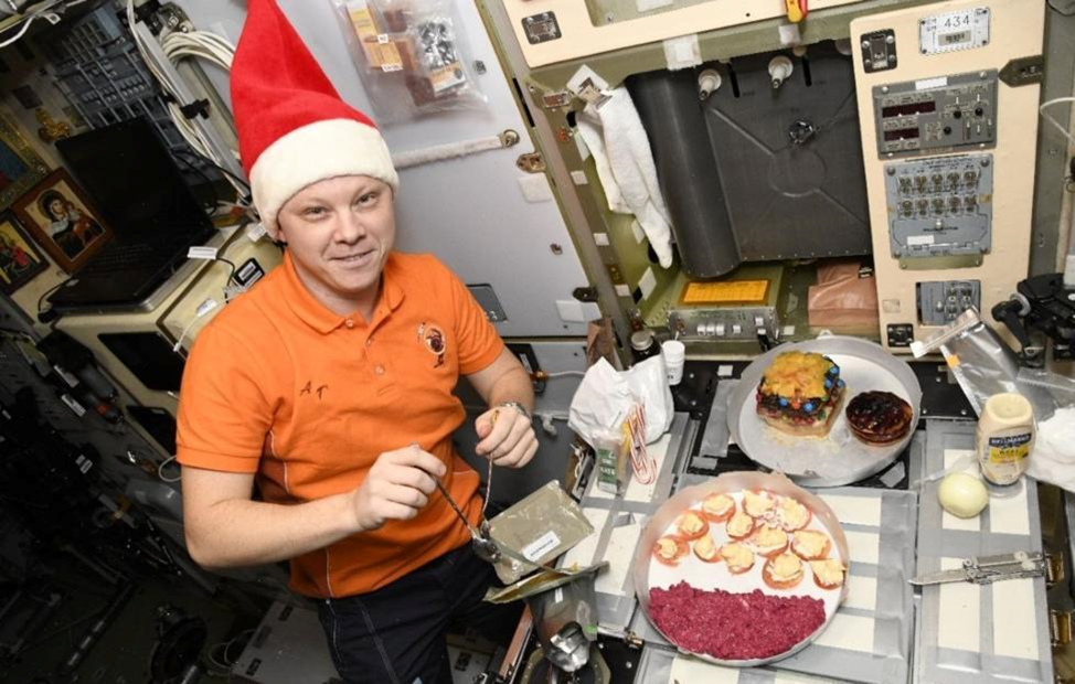 Александр Горбунов готовит новогодний торт. Фото: Роскосмос