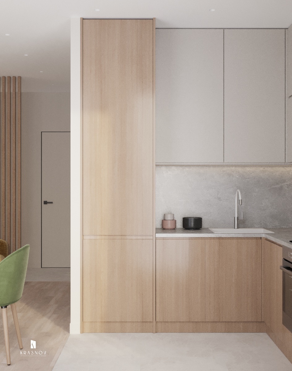 ✨ Кухонная зона выполнена в нейтральных тонах с элементами древесных текстур. Белые фасады и кухонный фартук с каменной текстурой создают ощущение лёгкости.