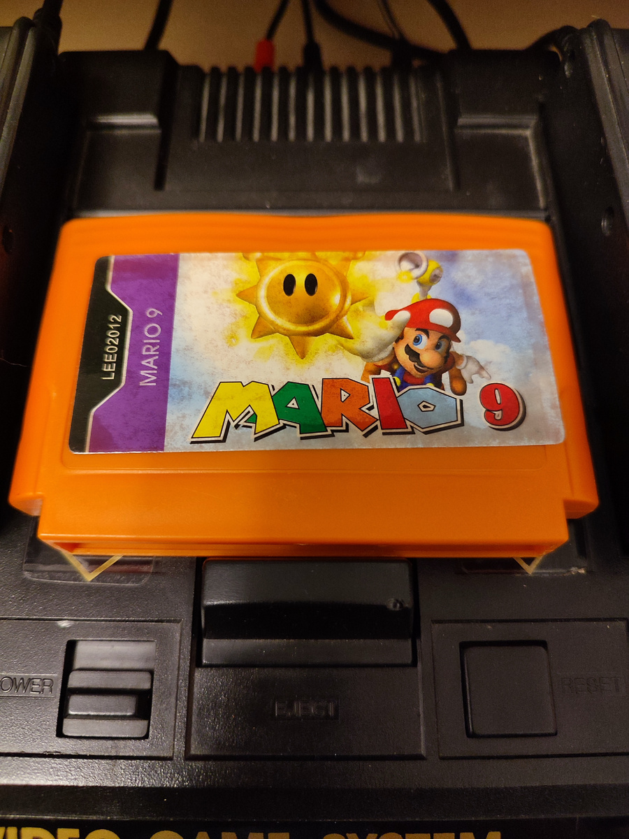 Фото сделаны мной. На фото игра "Mario 9", это хак (переделанная версия) игры "Остров приключений 2", "Adventure Island 2".  Оригинал игры "Adventure Island 2" был разработан Now Production и издан Hudson Soft в 1991,.г. для приставок Famicom. Дизайнер Дж. Коянаги, программист Нобуюки Шинохара. Фото демонстрирует начальную заставку игры, а так же общий визуальный фон игры. Подробнее об этом рассказано в статье. Все материалы принадлежат правообладателям и размещены исключительно в информационных целях.