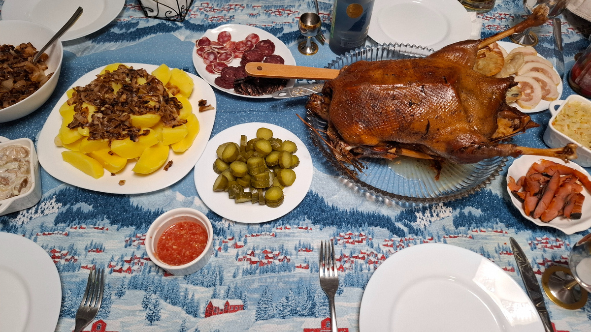 В центре - гусь, к нему картошечка с жареным луком,  огурчики, грибочки. 