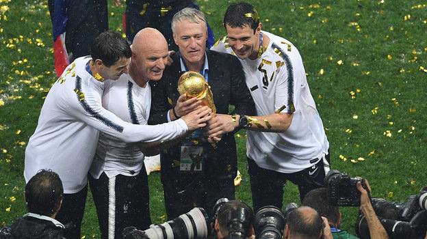    Тренерский штаб сборной Франции во главе с Дидье Дешамом с кубком за победу на чемпионате мира-2018.Дарья Исаева