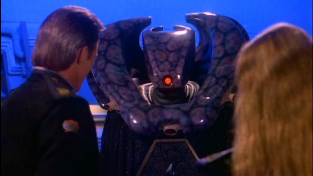 Посол Ворлонцев с командером Вавилона-5 Джоном Шериданом и командором ИвАновой на космической станции Вавилон-5, найдено в картинках.яндекса, ссылка на источник - https://www.moddb.com/groups/warhammer-dark-forcescience-fictionfantasyclan/images/vorlon (дата обращения 06.01.2025)