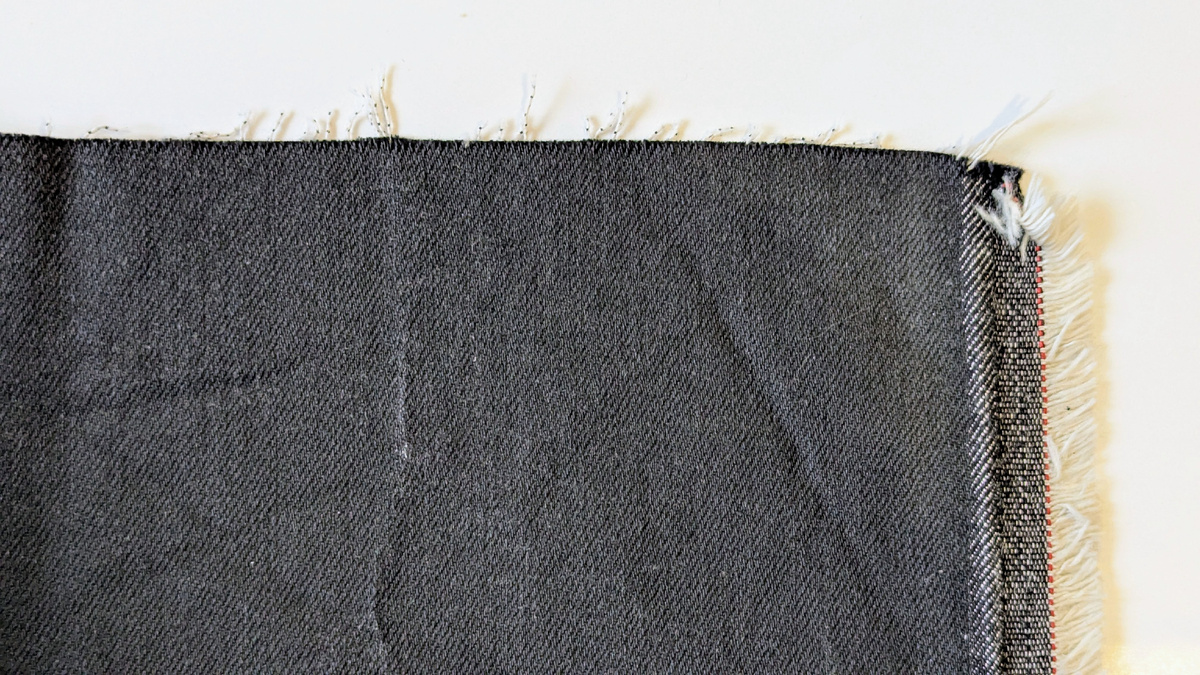 Нить основы на джинсовой ткани легко найти, она параллельна кромке.