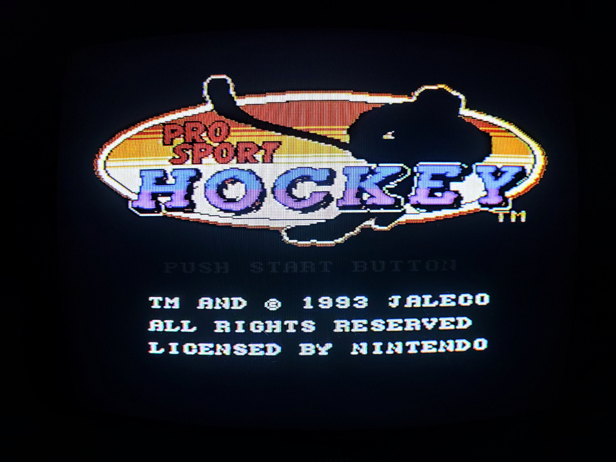 Фото сделаны мной. На фото игра "Pro Sport Hockey". Оригинал игры "Pro Sport Hockey" был разработан Tose и издан Jaleco в 1993г. для NES, SNES. Фото демонстрирует начальную заставку игры, а так же общий визуальный фон игры. Подробнее об этом рассказано в статье. Все материалы принадлежат правообладателям и размещены исключительно в информационных целях.