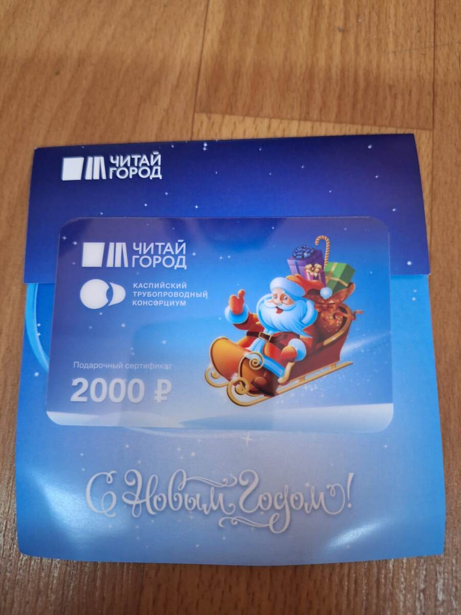 Тифлокомментарий. Подарочная карта на две тысячи рублей с изображением Деда Мороза на санях