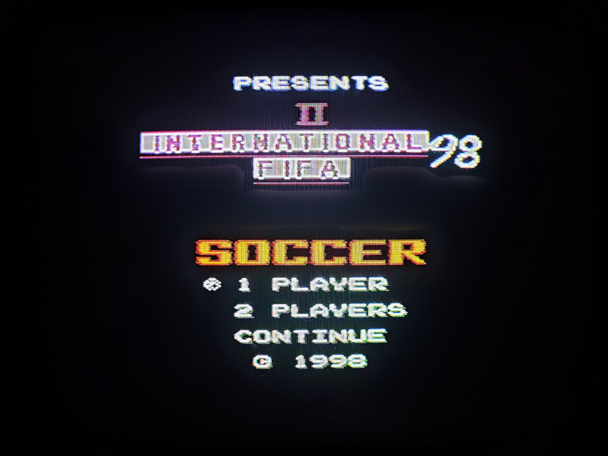 Фото сделаны мной. На фото игра "Tecmo World Cup Soccer". Оригинал игры "Tehkan World Cup" был разработан и издан "Tecmo" в 1985г. для аркадных автоматов. И портирован той же компанией "Tecmo" на NES под названием "Tecmo World Cup Soccer" в 1990г.  Фото демонстрирует начальную заставку игры, а так же общий визуальный фон игры. Подробнее об этом рассказано в статье. Все материалы принадлежат правообладателям и размещены исключительно в информационных целях.