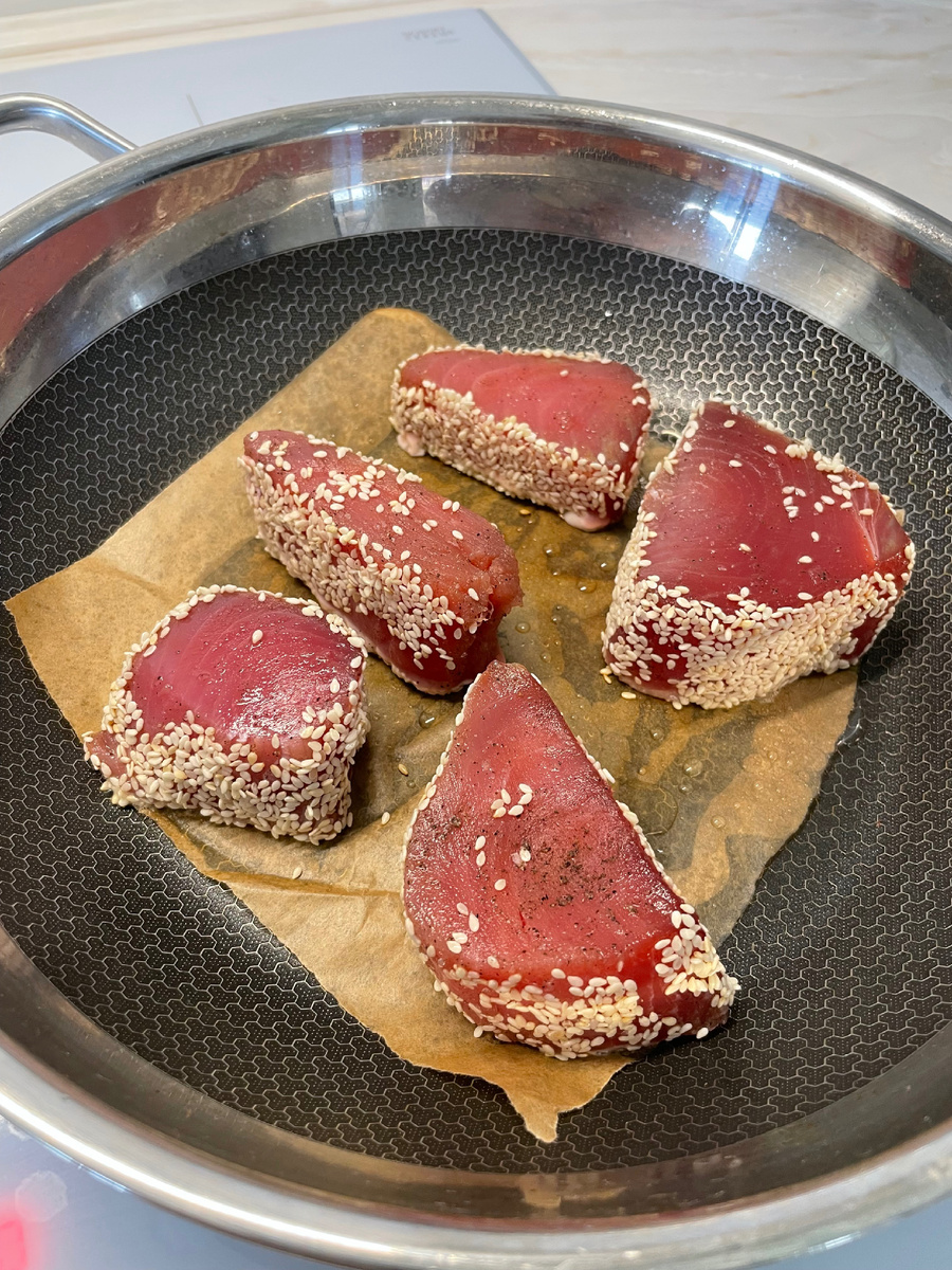 Кусочки тунца обмакиваем в кунжут и обжариваем на пергаменте с ложечкой масла около 3-х минут с каждой стороны.