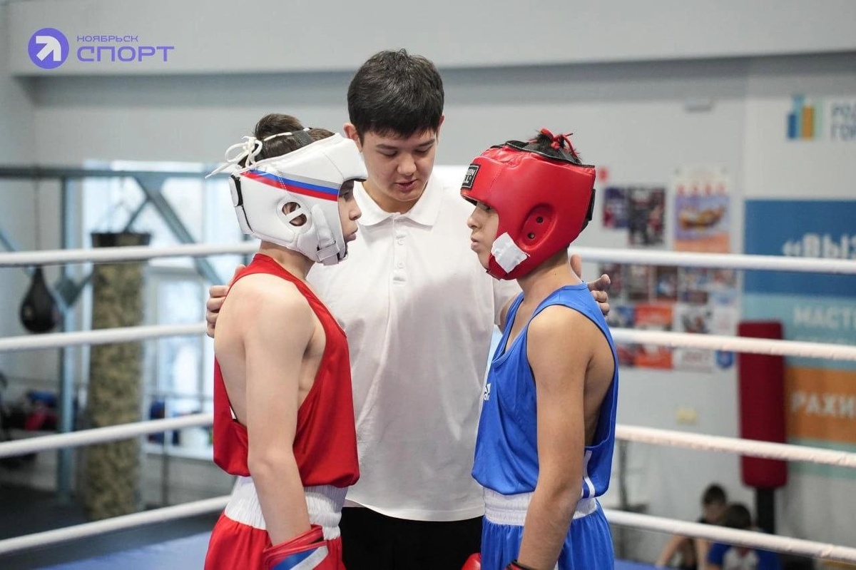 На ринге спортсмены приветствуют друг друга перед боем, показывая свою готовность и уважение к сопернику. 