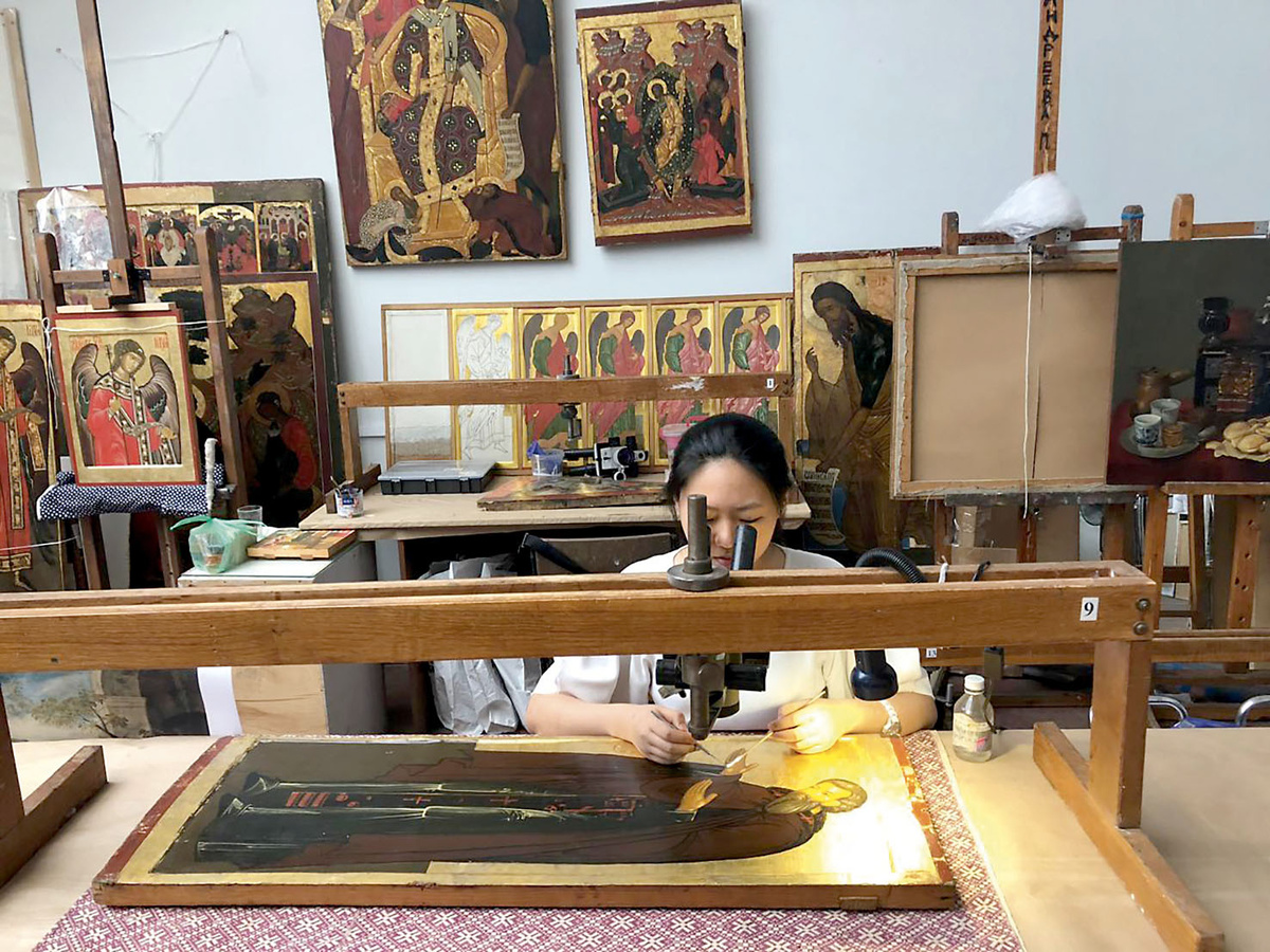 Студентка кафедры реставрации живописи Санкт-Петербургской академии художеств имени Ильи Репина Тун Синьюань за копированием древнерусской иконы. 2017
