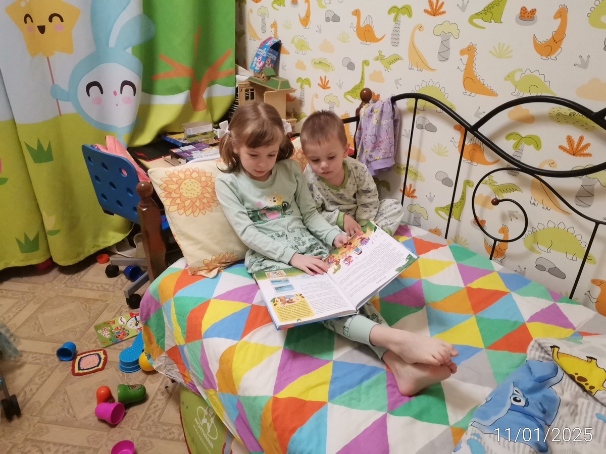 "Читает" брату, то есть пересказывает от себя книгу. 