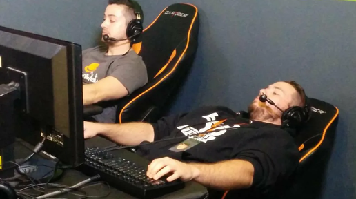 геймер сидит за двумя игровыми мониторами