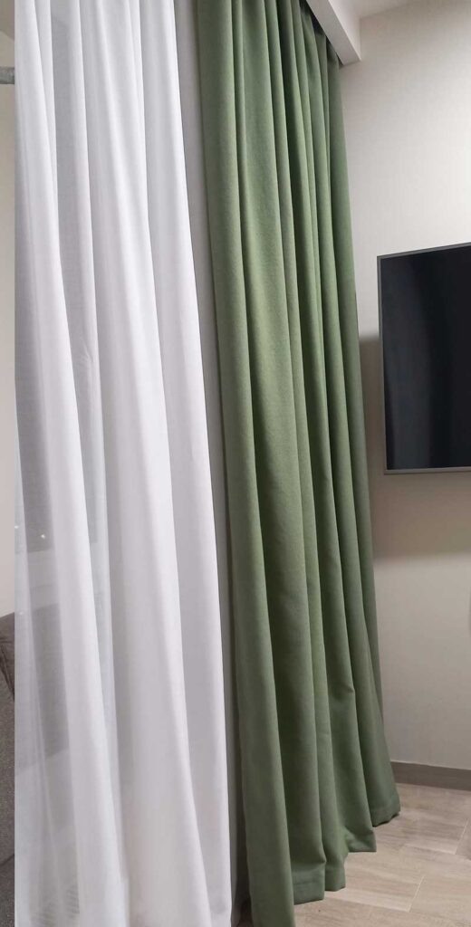 Однотонные портьеры зеленого цвета и однотонный тюль