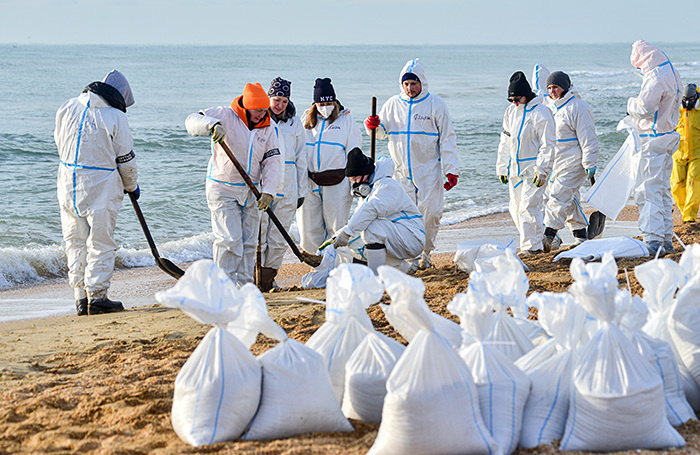    Волонтеры собирают песок с мазутом на пляжах Анапы.Игорь Онучин/ТАСС