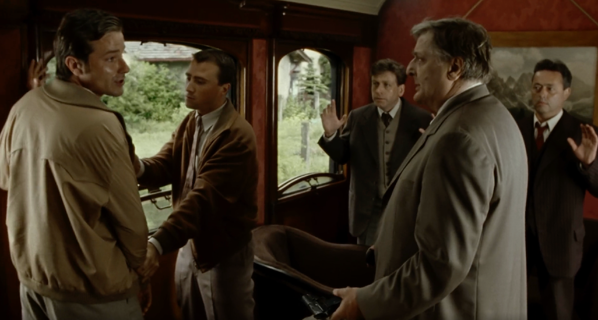 Кадр из серии, где Мегрэ пытается успокоить одного пассажира