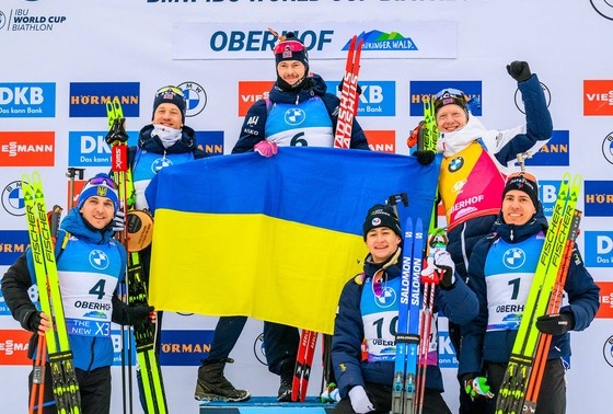    Спортсмены вместе держат украинский флаг. Германия, Тюрингия, Кубок мира BMW IBU по биатлону в Оберхофе, 2025 год