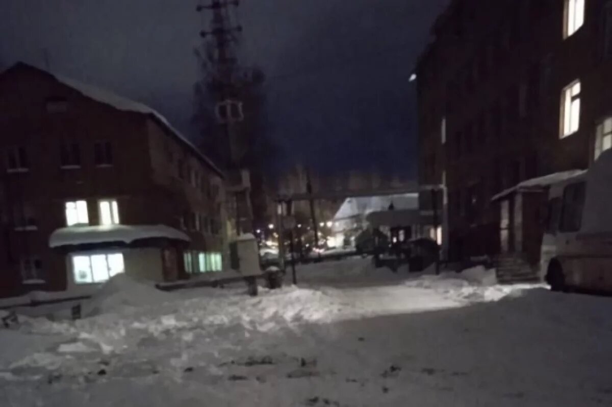    Переулок освещает только свет из окон.