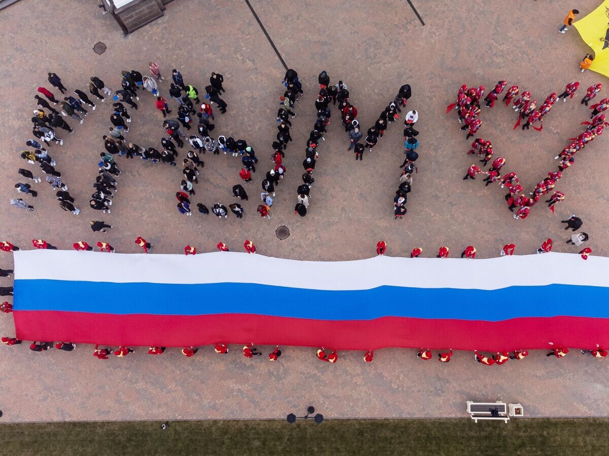   Участники акции, посвященной Дню воссоединения Крыма с Россией, на площади у Собора Андрея Первозданного в Геленджике© РИА Новости / Виталий Тимкив