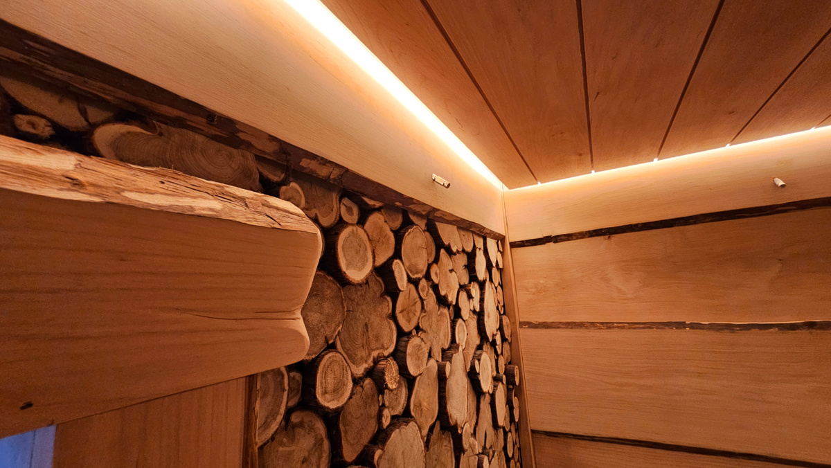 Стены обшиты спилами можжевельника и необрезной доской ольхи, так же под потолком можно увидеть систему туманообразования (мелкодисперсное распыление воды), такая система помогает немного охладить пар под потолком, а разница температуры опускает пар ниже, тем самым обволакивая вас, что доставляет особое удовольствие...