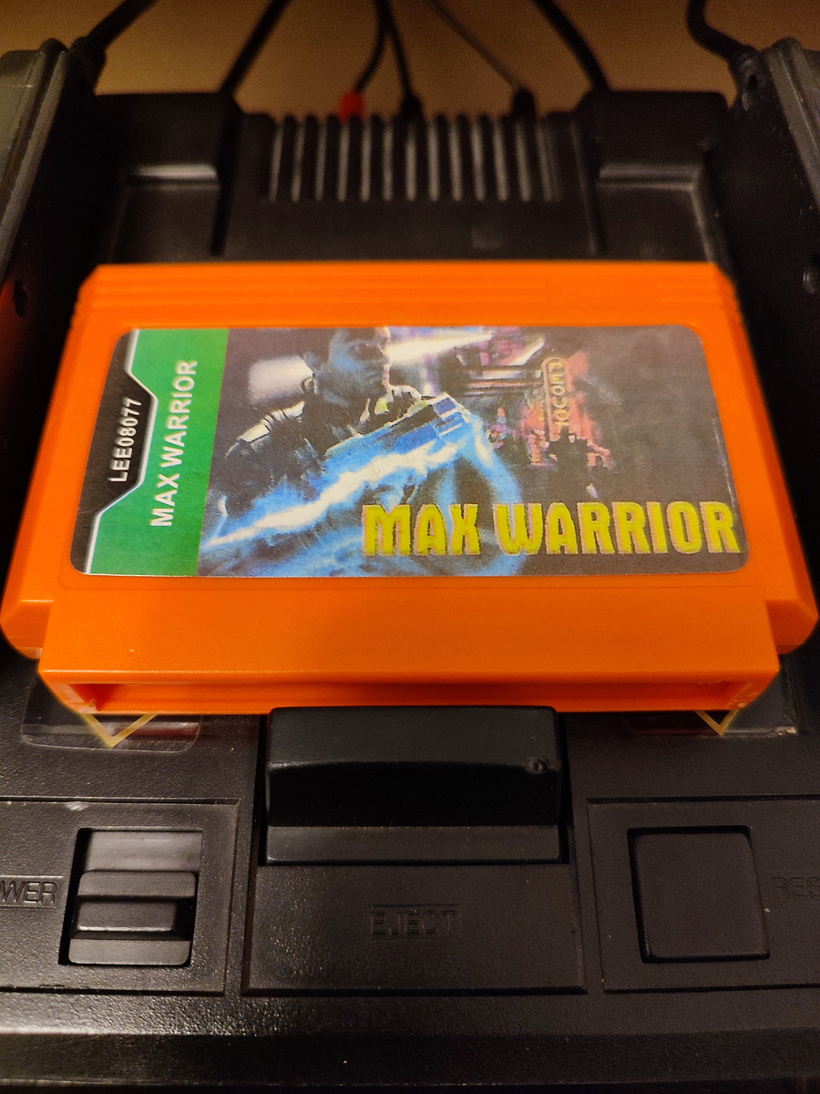 Фото сделаны мной. На фото игра "Max Warrior". Оригинал игры "Isolated Warrior" был разработан KID и издан VAP, Nintendo в 1991г. для NES. Продюсеры Харуо Окамото, Юдзи Имадзеки, дизайнер Г. Баба, программист Сёдзи Такаги. Фото демонстрирует начальную заставку игры, а так же общий визуальный фон игры. Подробнее об этом рассказано в статье. Все материалы принадлежат правообладателям и размещены исключительно в информационных целях.