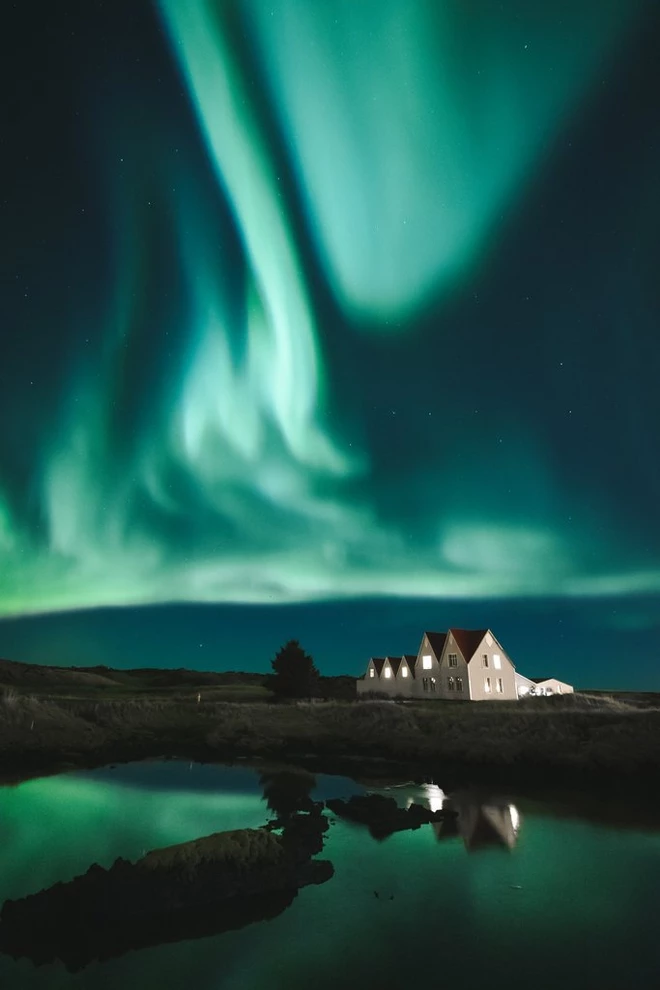 В качестве дополнительного штриха к такому завораживающему зрелищу, как северное сияние, Аса решила добавить некий объект на переднем плане. «Я нашла дом с освещенными окнами, который сделал изображение намного интереснее», — говорит она. Снимая такой объект, как северное сияние, важно просмотреть сделанные кадры и выбрать лучшие для постобработки. Снято на камеру Canon EOS-1D X Mark II с объективом Canon EF 16-35mm f/2.8L III USM и следующими параметрами: 16 мм, 2,5 сек, f/4 и ISO 3200. © Аса Стейнарс