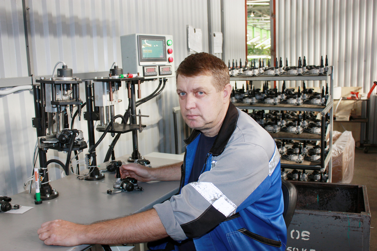 Слесарь механосборочных работ Геннадий Хорощенко работает на стенде регулировки прибора
