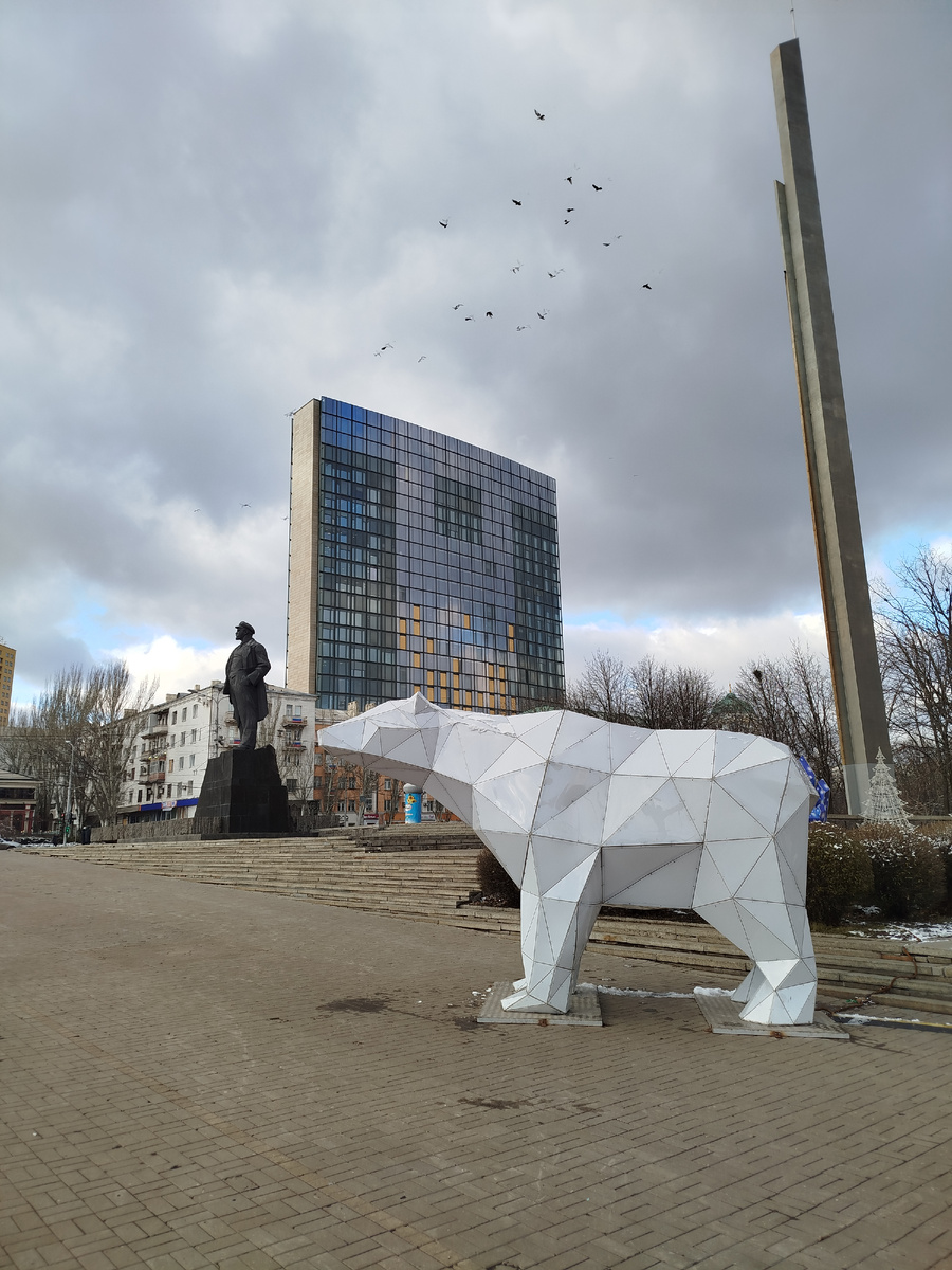 Новогодняя инсталляция в виде белого мишки на фоне Вождя Мирового Пролетариата и бизнес центра "Пушкинский" на площади имени Ленина.