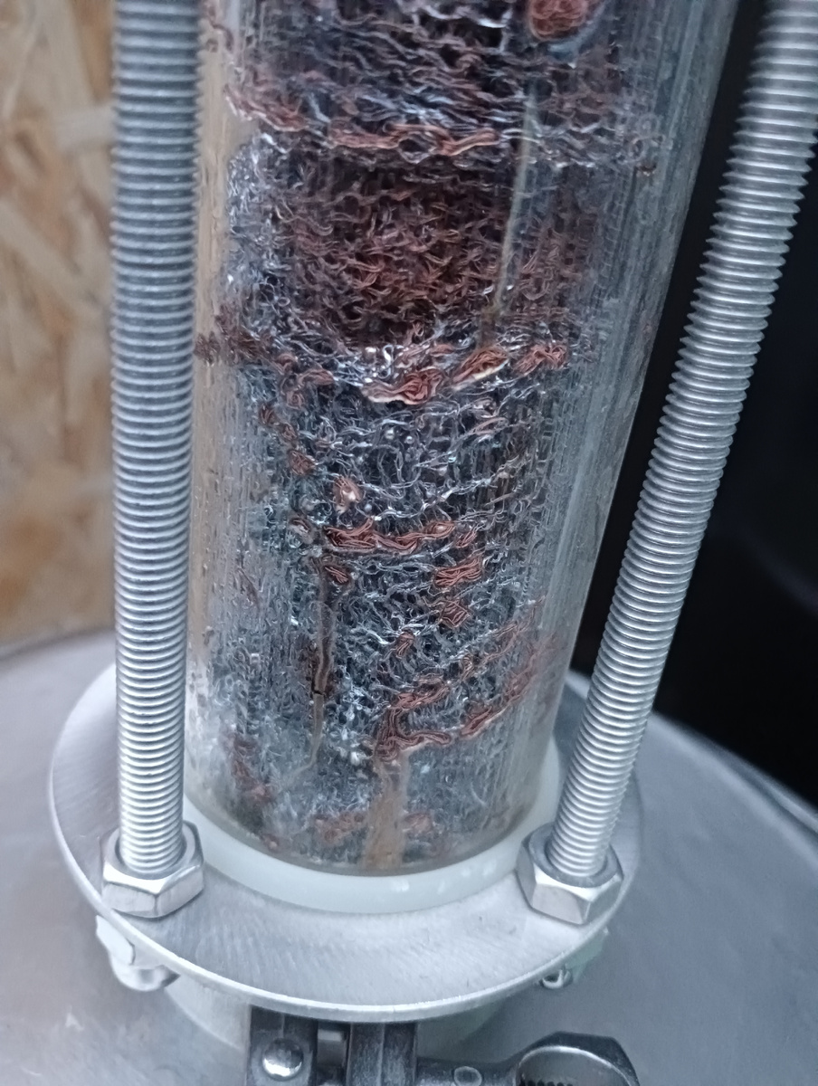 Пыжи медной сетки в царге-диоптре после перегонки. Хорошо видно загрязнение в виде отложений стального цвета на меди