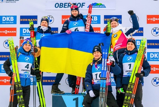    Спортсмены вместе держат украинский флаг. Германия, Тюрингия, Кубок мира BMW IBU по биатлону в Оберхофе, 2025 год