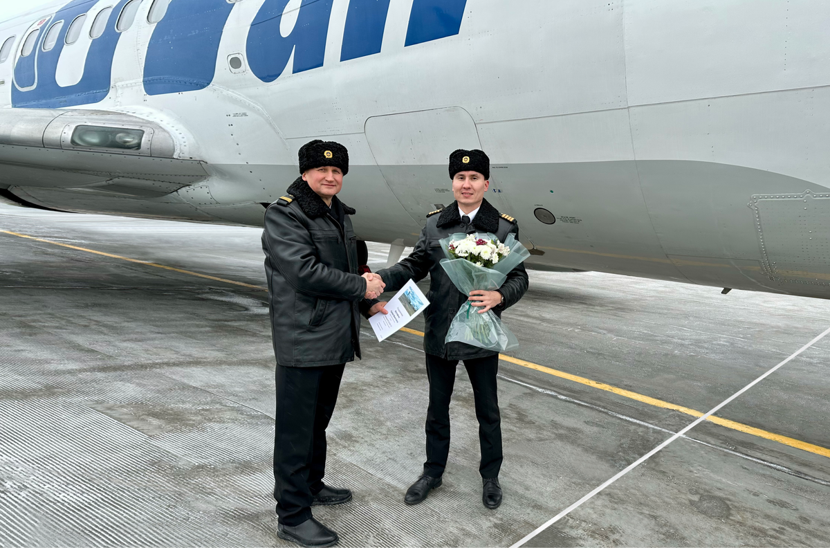 Командир летного отряда № 2 Павел Шевченко вручает благодарность генерального директора ПАО "Авиакомпания "ЮТэйр" Гумару Мустафину