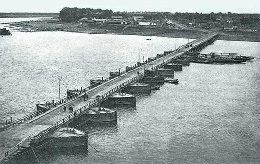 Плашкоутный мост. Набор небольших заякоренных лодок, на которые клали настил для мостовых пролетов. Разбирался на зиму. Частично разбирался для прохода судов. Фото из сети.