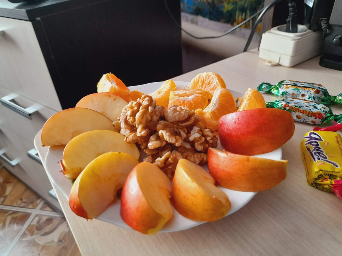 Это фруктовая нарезка стоит возле компьютера и орешки в ней 