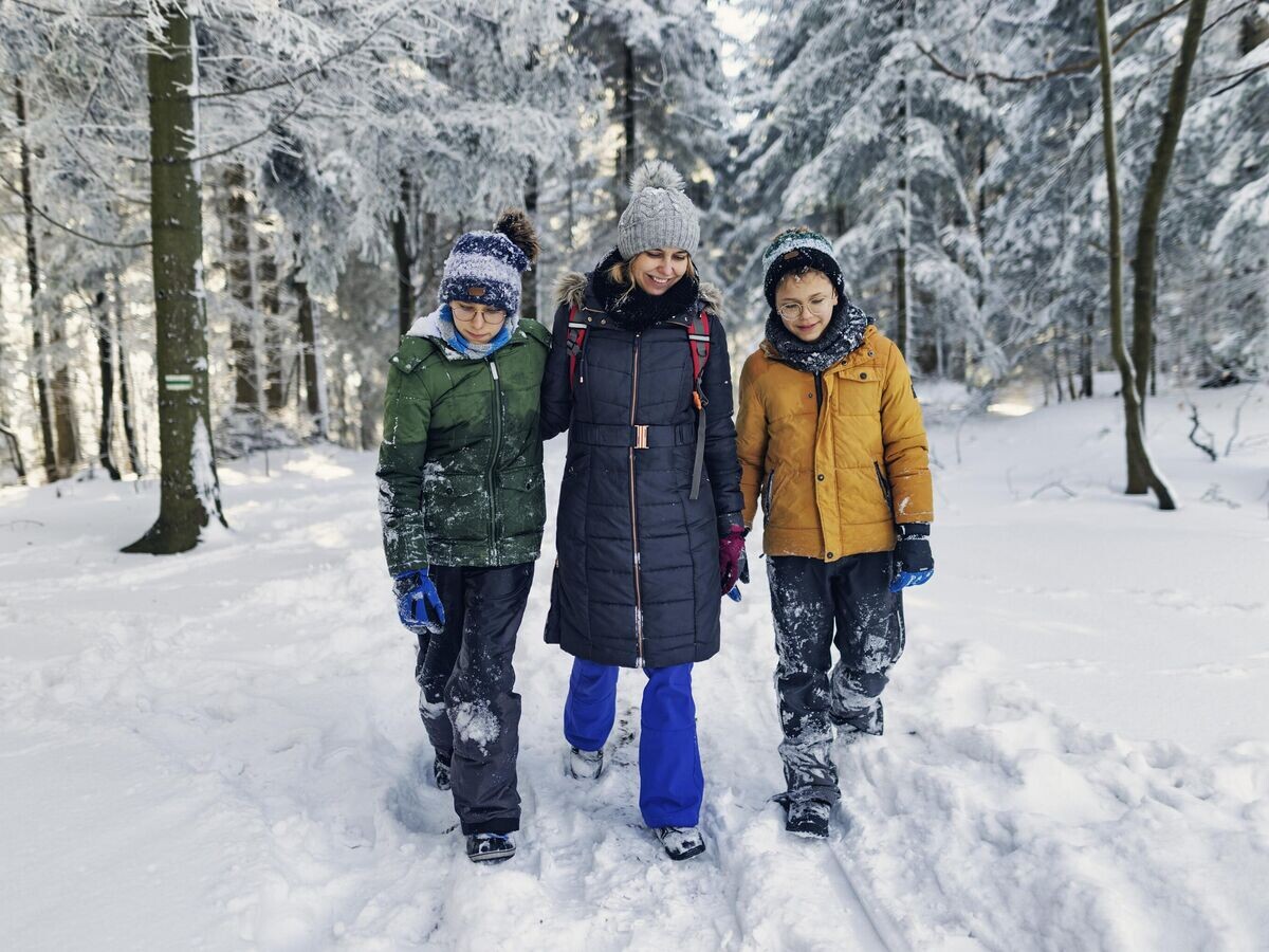    Мама с мальчиками-подростками в зимнем лесу© iStock.com / Imgorthand
