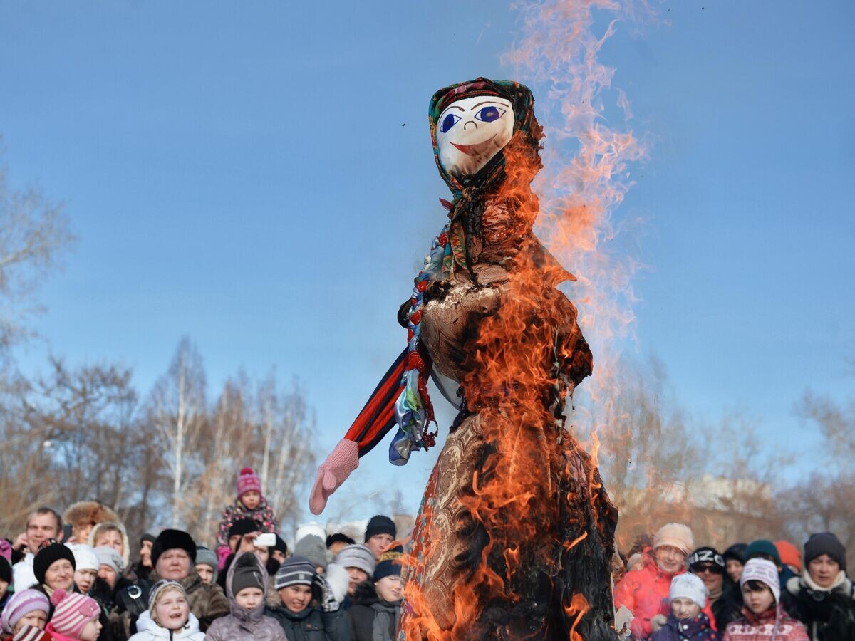    Отдыхающие наблюдают за сожжением чучела Зимы на праздновании Широкой масленицы в Харитоновском парке в Екатеринбурге© РИА Новости / Павел Лисицын